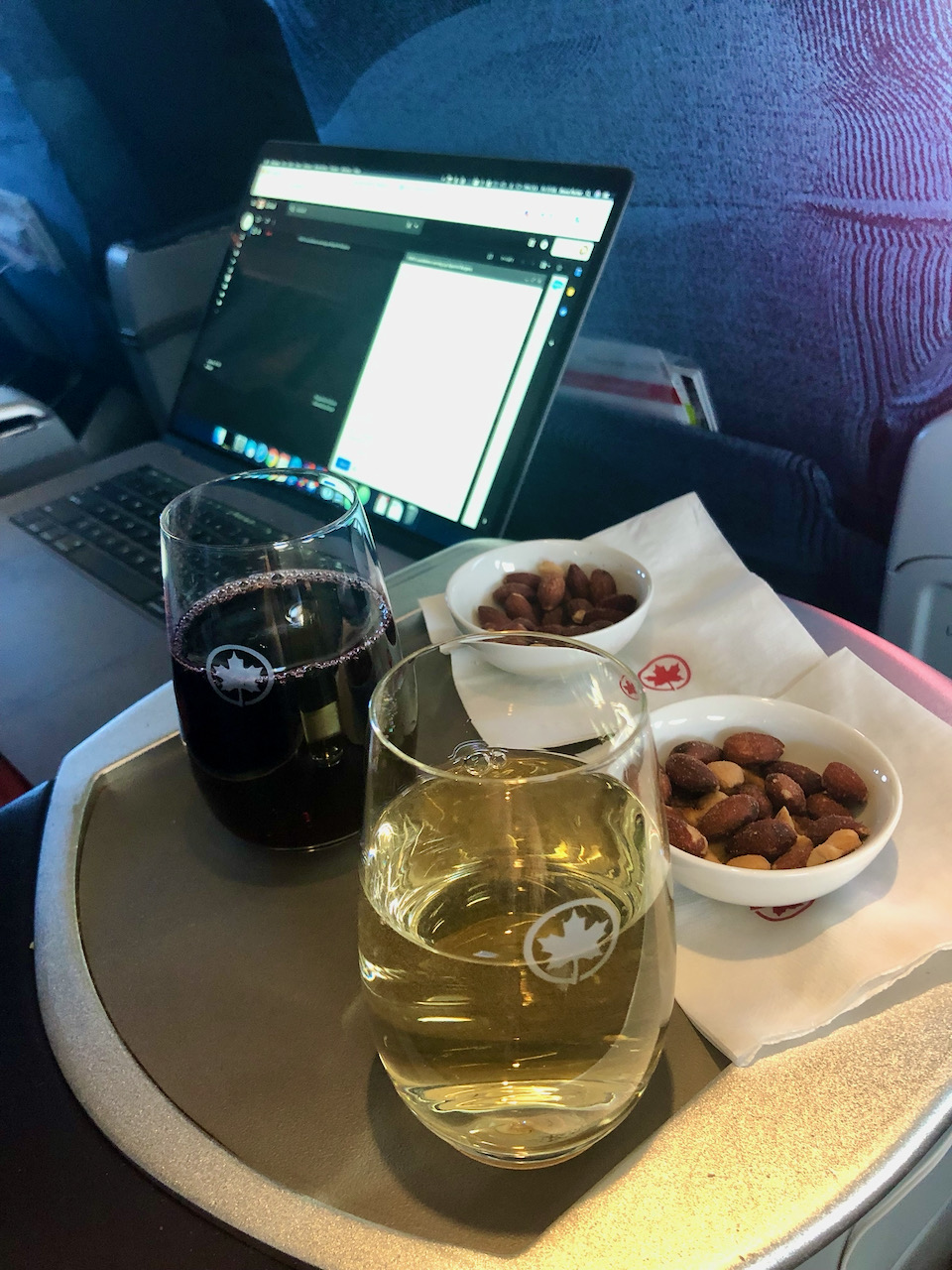 Post-pandemic business travel - Glasses of wine with laptop on a plane